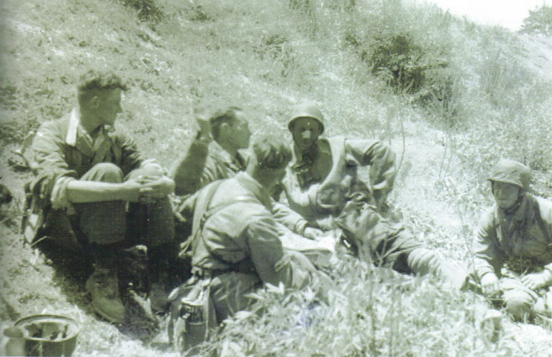 Hauptmann Gericke commanding officer of the IV/3rd FjSR, taking a break amongst some of his men. Gericke is the one with his hand up and a map on his lap.