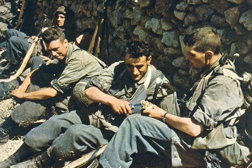 German paratroopers during a lull in the Battle of Crete. One is seen holding a gravity knife.