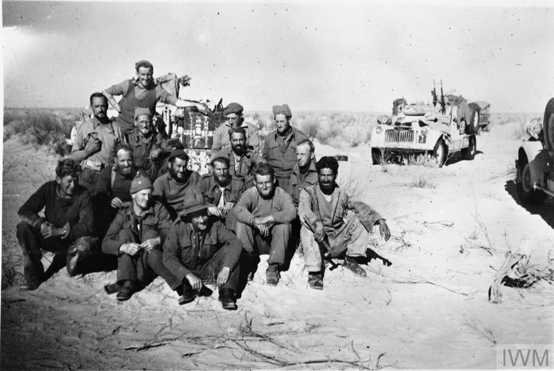 A group of Long Range Desert Group men pose for a photograph in front of their vehicles, having become the first 8th Army unit to cross the Tunisian border. At this time, LRDG patrols were being tasked by Montgomery to reconnoitre the 'going' in southern Tunisia, in case the 8th Army had to bypass the strongly held Mareth Line. Copyright: © IWM. Original Source: http://www.iwm.org.uk/collections/item/object/205125575