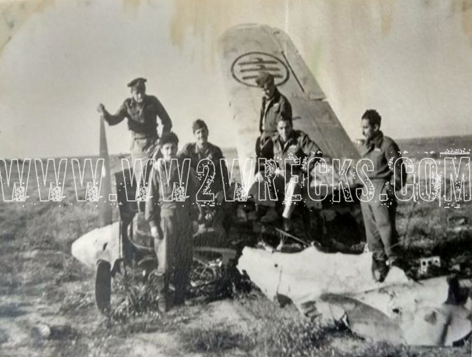 Ο Ιωάννης Κατσαρός με συναδέλφους του, σε ένα κατεστραμμένο αεροσκάφος της Regia Aeronautica, της Βασιλικής Αεροπορίας της Ιταλίας, στην έρημο της Β. Αφρικής. 