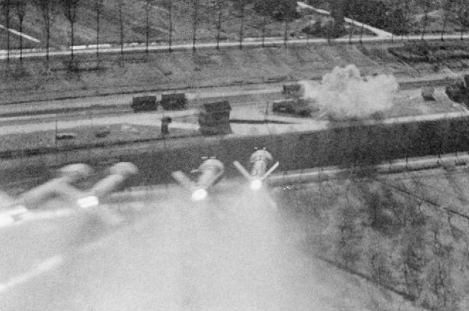Hawker Typhoon gun camera photo of a rocket salvo fired at railway wagons in a siding at Nordhorn, Germany (1945) Photo by Shaw (F/Sgt), RAF photographer - This photograph CL 2362 comes from the collections of the Imperial War Museums (collection no. 4700-19) 2ND TACTICAL AIR FORCE, 1943-1945. Still from film shot by a Hawker Typhoon of No. 181 Squadron RAF while attacking trucks in railways sidings at Nordhorn, Germany, showing a salvo of 60-lb rocket projectiles heading for the target, which has already been hit. Public Domain